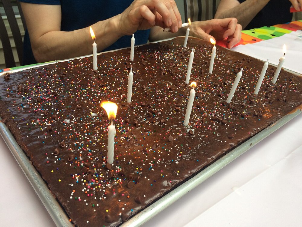 עוגת שוקולד מלבנית גדולה על מגש עם נרות דולקים